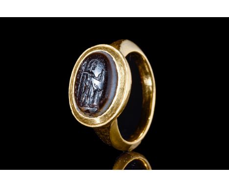 Ca. 100-200 AD.A banded agate intaglio in a gold ring showing a detailed portrait of Jupiter holding a staff and an eagle. Si