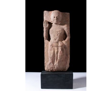 Ca. 100-200 AD.A rectangular red sandstone relief with an arched top. The relief depicts Buddha standing in samabhanga on a s