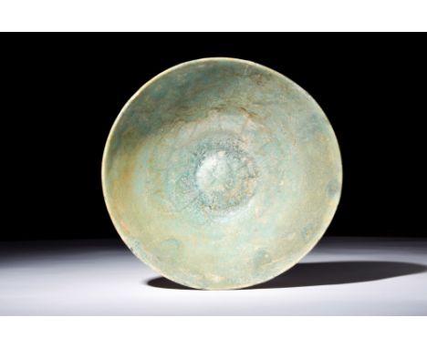 Ca. 1100-1200 AD.A pottery bowl with a truncated conical form, elevated foot, and light turquoise glaze displaying cracks. Si