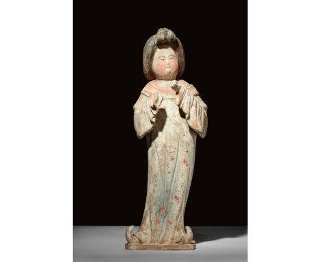 Ca. 618-907 AD.A terracotta figure, commonly known as the 'Fat Lady'. The woman stands in in a swayed posture with a long rob