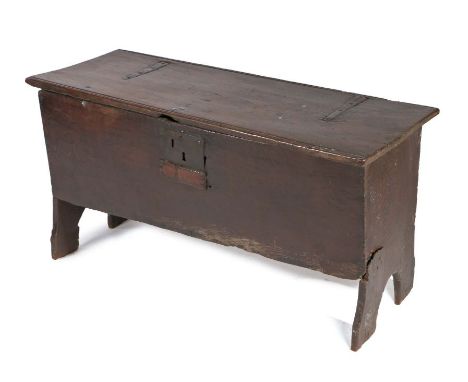 17th Century oak coffer, the rectangular top with hinges cut into the panel above a single panel front and shaped supports, 1