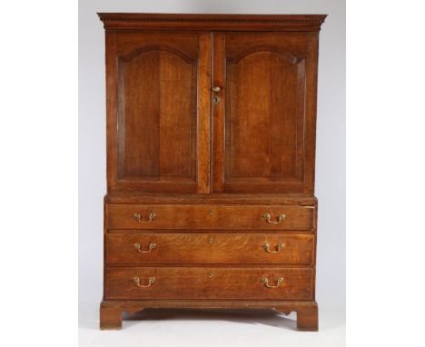 George III oak linen press, circa 1800, the concave cornice above a dentil moulded frieze and a pair of fielded arched panel 