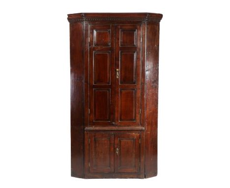 George III oak standing corner cupboard, the concave dentil moulded cornice above a pair of fielded panel doors enclosing sha