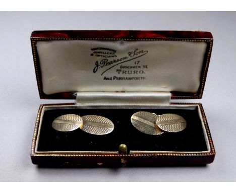 A pair of 9ct gold cufflinks - with engine turned decoration on oval buttons joined by a chain, weight 3.1g.
