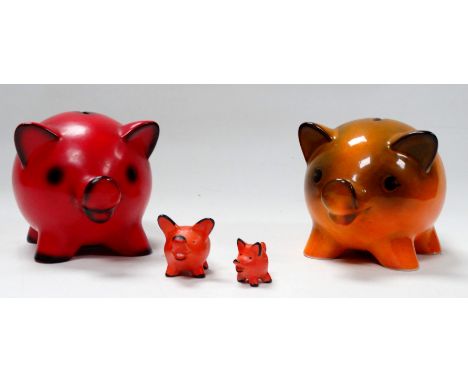 A Goebel pottery piggy bank - orange glazed, 18cm wide, together with another similar red glazed example and two small potter