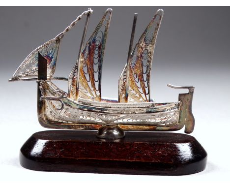 A silver filagree sailing boat, width 6.5cm - on wooden stand. 