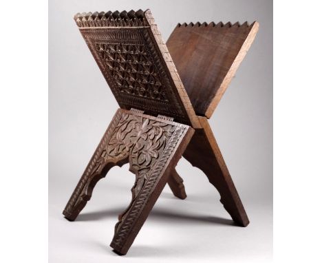 A late 19th century carved Quran stand - folding X frame, decorated with flower head and geometric carving, height 32cm.