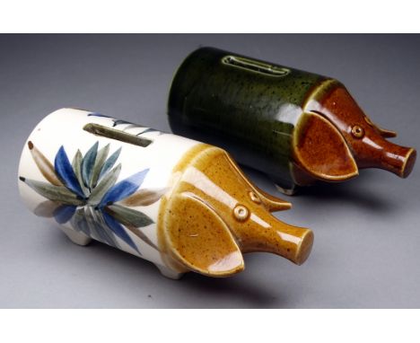 A 20th century ceramic piggy bank - of cylindrical form, decorated with a leaf design, 15cm long, together with another, (2)