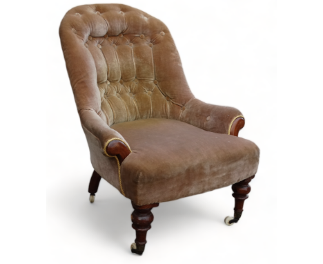 A Victorian walnut button upholstered low seat chair - the spoon shape back raised on turned tapering legs with brass and cer