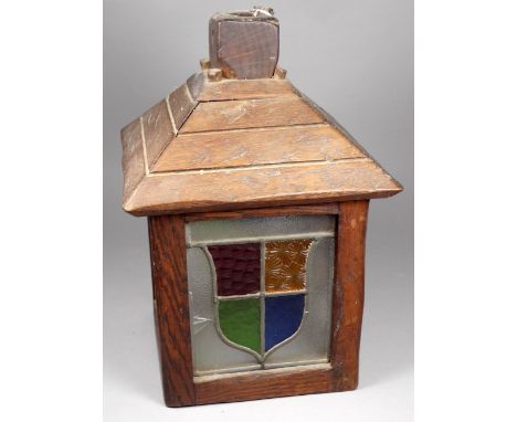 An oak and stained glass Arts and Crafts style lamp shade - square fitted with shield shaped panels, height 30cm.