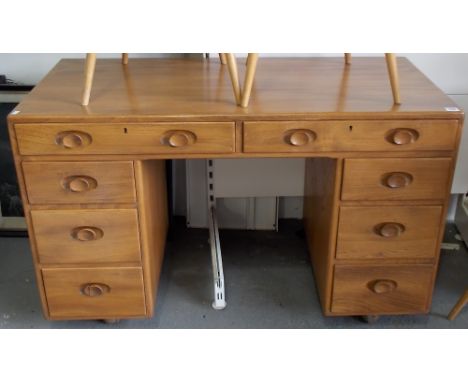 Good Ercol pale elm knee hole desk with an arrangement of eight drawers, width 46'.