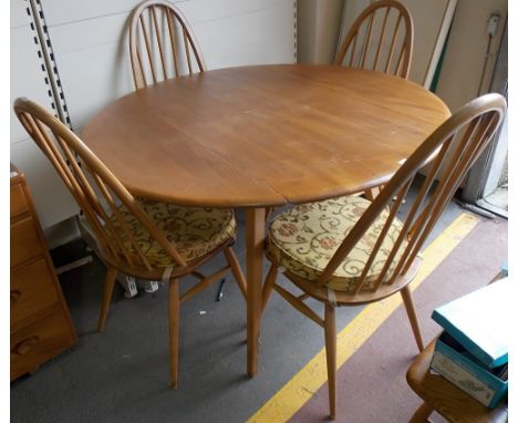 Ercol pale elm oval extending dining table, together with a set of four spindle back dining chairs.