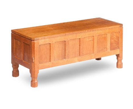 A Robert 'Mouseman' Thompson oak coffer,The cleated adzed top over a six panel front, on chamfered block legs with octagonal 