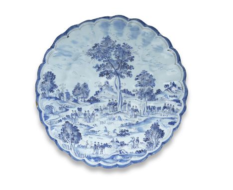 A Hanau faience chargerCirca 1680-1700Of pleated shape, decorated with an elaborate bucolic landscape with figures in various