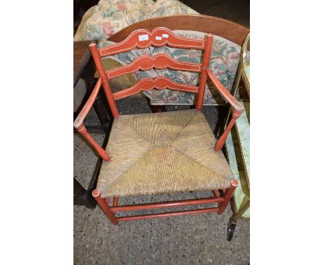 A rush seated ladder back armchair with red painted frame