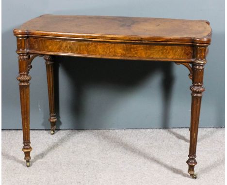 A Victorian figured walnut rectangular card table with slightly bowed sides and rounded corners, with moulded edge to baize l