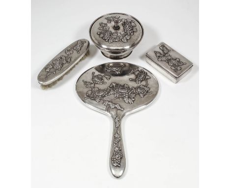 A Chinese silvery metal part dressing table set cast in relief with chrysanthemums, comprising, - hand mirror, clothes brush,