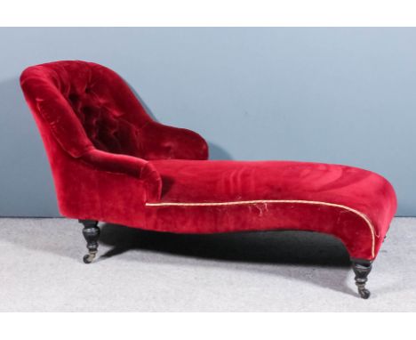 A late Victorian chaise lounge with spoon shaped end, upholstered in deep wine dralon, the end buttoned, on turned and ebonis