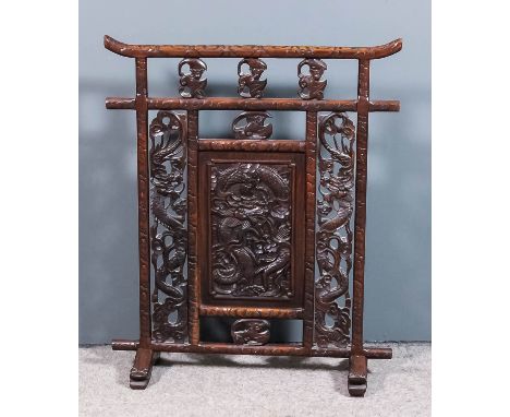 A Chinese hardwood rectangular fire screen inset with central panel carved with a dragon and with similar fretted and carved 