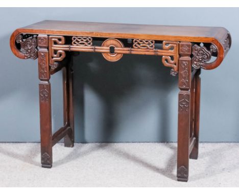 A Chinese hardwood rectangular altar table with flush panelled top and scroll ends, the front and rear fretted and carved wit