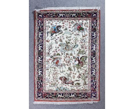 A modern Isfahan silk rug woven in colours with a hunting scene with six huntsmen on horseback and flowering trees, animals a