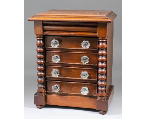 A late Victorian mahogany miniature chest of five drawers, the top drawer with shaped front, flanked by bobbin turned columns