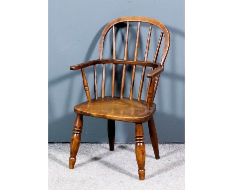 A 19th Century child's ash and elm seated stick back Windsor armchair with two tier back and arched crest rail, wood seat, an