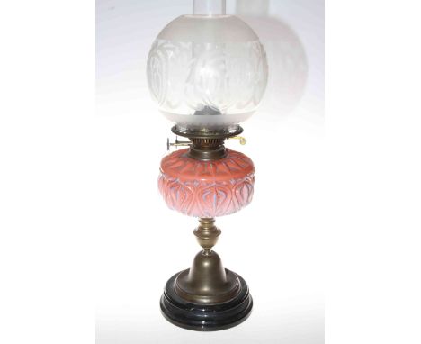 Brass oil lamp with pink glass reservoir and frosted glass shade.