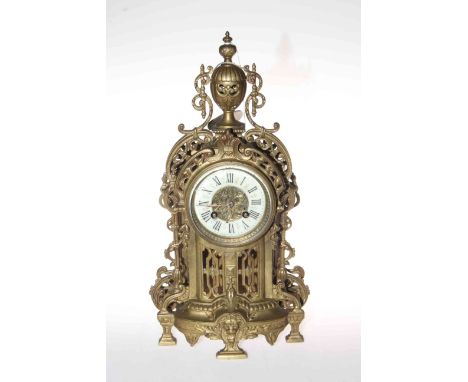 Ornate gilt metal mantel clock with enamel Roman numeral dial.
