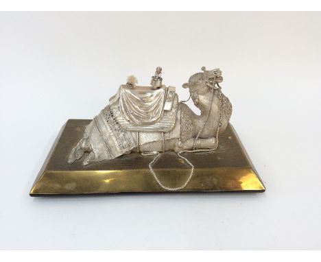 An Eastern white metal and brass desk top lighter, in the form of a reclining camel, 25cm long overall; and a collection of q
