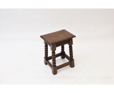An oak joint stool, raised on bobbin turned supports, united by stretchers on block feet, 39cm