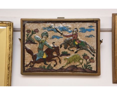 An Isnic tile, depicting a hunting scene contained in a gilded frame, 25cm x 35.5cm 