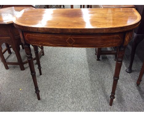 A George III mahogany satin wood cross banded D shaped card table, the fold over swivel top raised on ring turned tapering su