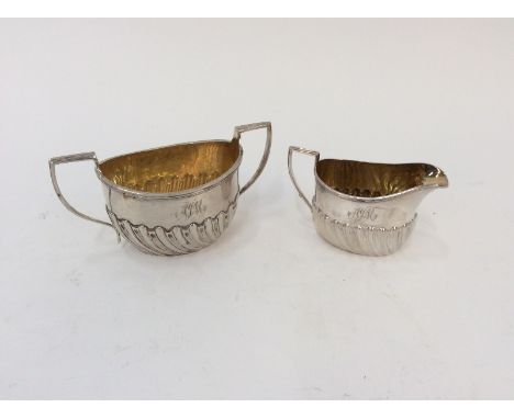 A small silver sucrier, of half fluted body design with gilded interior, London 1900; and a similar cream jug, Sheffield 1891