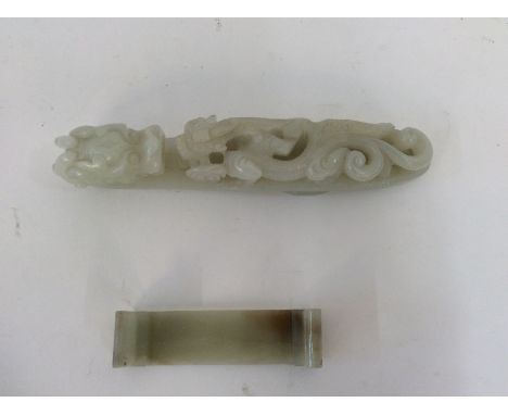 A Chinese pale green jade belt hook, 19th Century, the hook carved as a dragon's head, the reverse with circular boss, 15cm