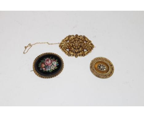 A Victorian yellow metal foliate scroll brooch, in a fitted box, stamped Kuss & Co.; a yellow metal oval brooch with enamel a