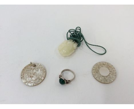A carved jade floral pendant; two mother of pearl carved pendants and a silver and jade set ring