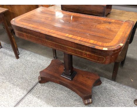 A Regency rosewood, satinwood cross-banded and brass strung card table, the foldover top raised on a square column above quat