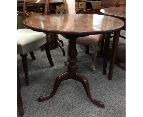 A George III mahogany tripod tea table, the circular snap top raised on a bird cage movement and turned baluster column, 77.5