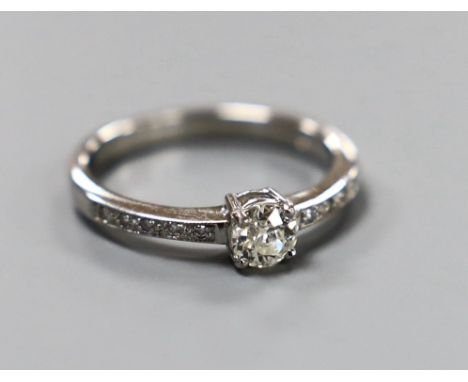 A modern platinum and single stone diamond ring, with diamond set shoulders, size M, gross weight 3.7 grams, total diamond we