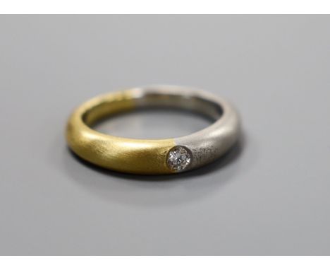 A modern sandblasted plat and 750 yellow metal ring, with gypsy set diamond, size M, gross weight 7.1 grams, the stone weighi