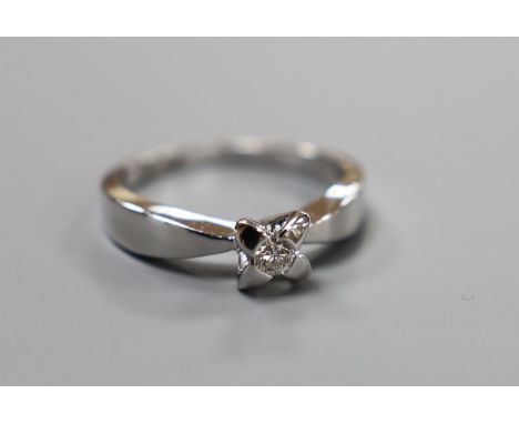 A modern platinum and single stone diamond set ring, size N, gross weight 6 grams, the diamond weighing approx. 0.10ct.