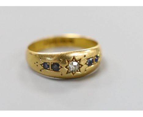 A late Victorian 18ct gold, single stone diamond and four stone sapphire gypsy set ring, size N, gross weight 3.2 grams.