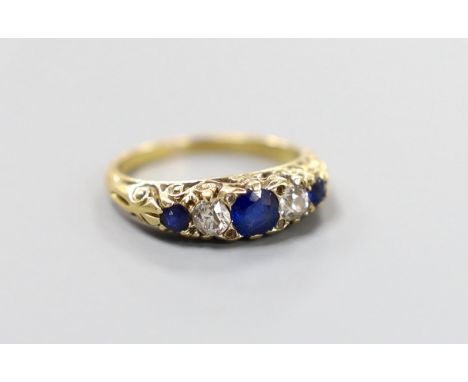 A yellow metal, three stone sapphire and two stone diamond set half hoop ring, with carved setting, size K, gross weight 3.6 