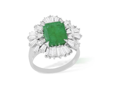 AN EMERALD AND DIAMOND RINGSet with a rectangular-shaped emerald, within an undulating surround, further set with tapered bag