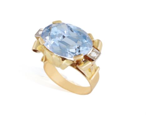 A SYNTHETIC SPINEL AND DIAMOND RING, CIRCA 1950Set with an oval-shaped synthetic spinel, to a scrolled mount enhanced by sing