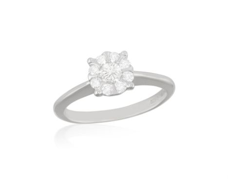 A DIAMOND RINGSet with a brilliant-cut diamond, within a brilliant-cut diamond surround, mounted in 18K white gold, maker’s m