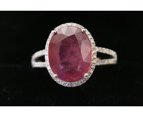 A 14k white gold and diamond ring set with an oval cut ruby approx 5.30ct diamonds approx 0.40ct total weight