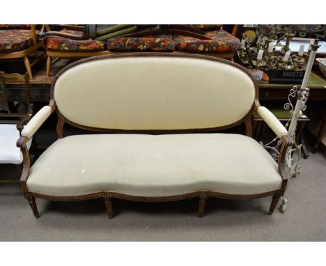 A French sofa, the oval back with oak carved frame having open arms and turned flutter legs