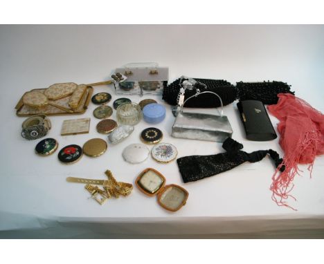A box containing various vintage items including bags and compacts